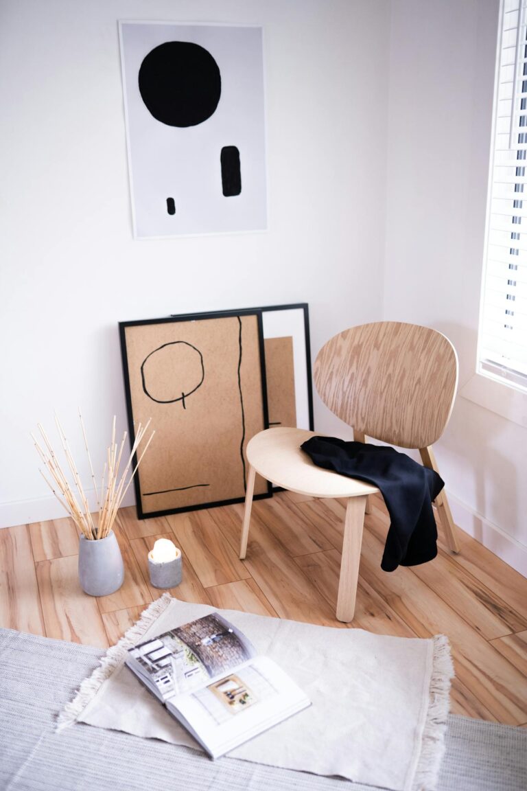 Elegant minimalist room featuring a chair and abstract art for a serene atmosphere.